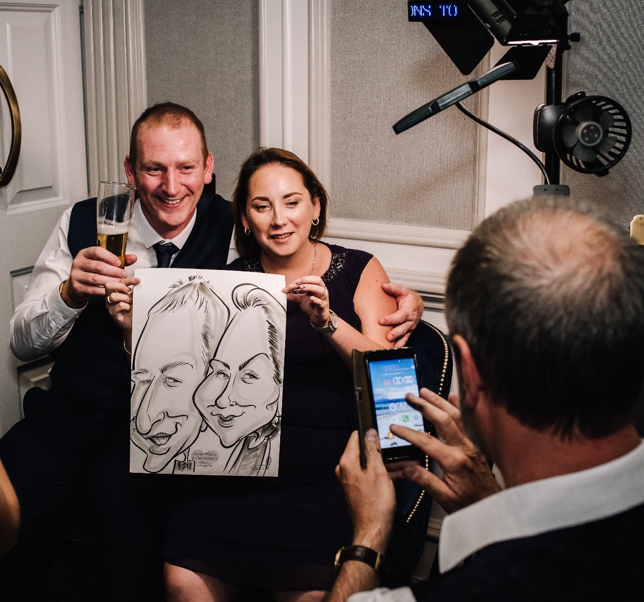 Anne-Marie and Christopher pose with their caricature from Tony's Toons Caricatures
