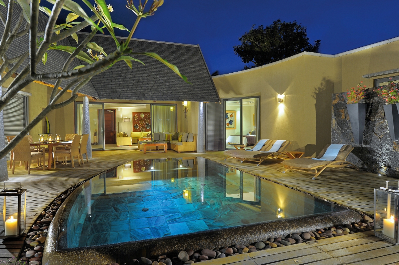 villa suite at night with pool and loungers