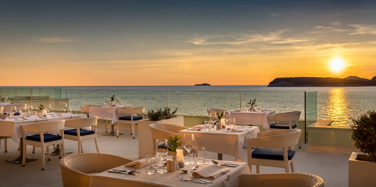 restaurant tables on a terrace with sunset views