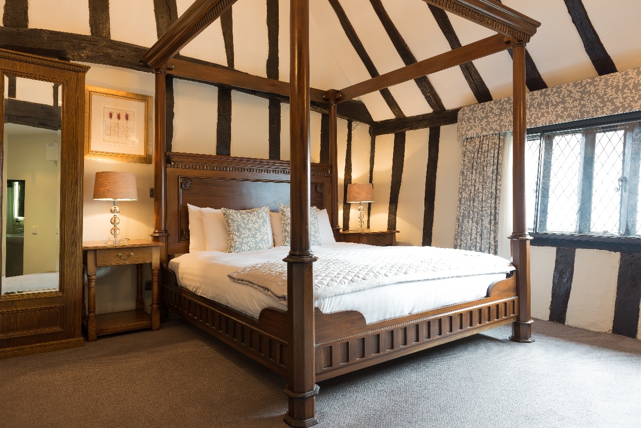 wood-beamed room with fourposter bed